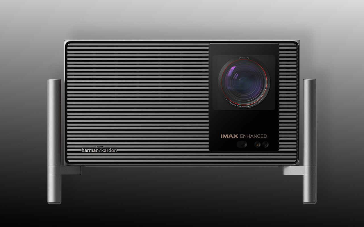 IMAX Enhanced projector with a large lens on a striped black chassis and metal legs.